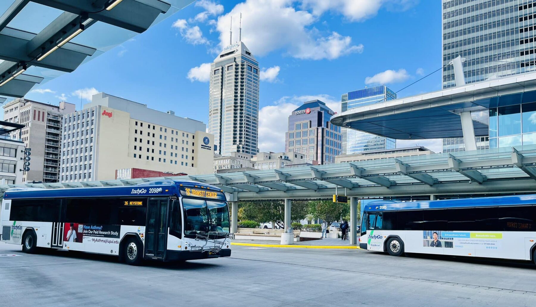 Buses at Carson Transit Center with Indianapolis skyline in background
