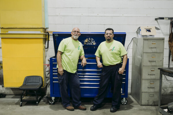 Two IndyGo mechanics standing in front of tool box